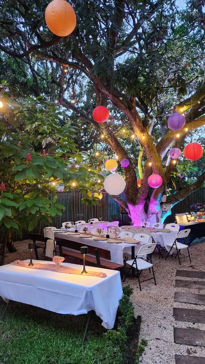 Mesa de evento bajo el árbol con faroles
