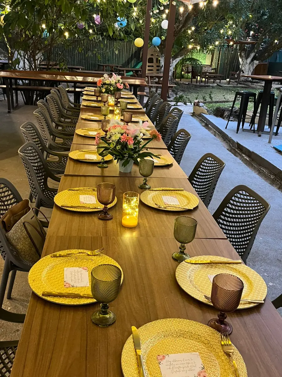 Mesa larga decorada bajo la pérgola